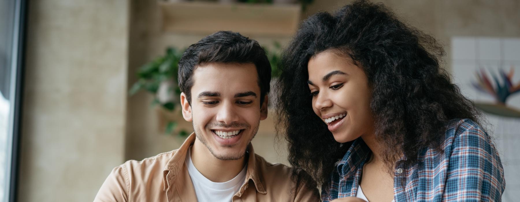 a man and woman smiling at a table with food